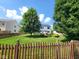 Beautiful backyard featuring a large lawn, wooden fence, pergola, and lush landscaping at 8433 Vyners Ln, Avon, IN 46123