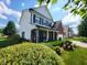 Two-story home featuring black window shutters, a brick facade, and a covered front porch with seating at 8433 Vyners Ln, Avon, IN 46123
