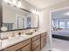Modern bathroom with a double vanity, large mirror, and access to a bedroom at 9124 Anthem Ave, Plainfield, IN 46168