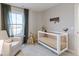 Calming Bedroom features a crib, glider, and playful decorations at 9124 Anthem Ave, Plainfield, IN 46168