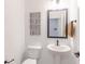 Simple powder room features pedestal sink, modern mirror, and updated fixtures at 9124 Anthem Ave, Plainfield, IN 46168
