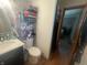 Small bathroom with toilet, vanity, mirror, floral wallpaper, and view into the next room at 9783 Lee Ct, Columbus, IN 47203