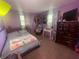Lavender bedroom featuring a bed, and windows offering natural light and dark hardwood furniture at 9783 Lee Ct, Columbus, IN 47203
