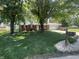 Charming brick ranch home with mature trees and a lush green lawn in a serene neighborhood at 9783 Lee Ct, Columbus, IN 47203