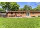 The brick home's backyard features a well-maintained lawn and patio with outdoor furniture at 3331 Loral Dr, Anderson, IN 46013