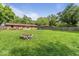 Brick home's spacious backyard with a lush lawn, fire pit, and mature trees at 3331 Loral Dr, Anderson, IN 46013