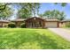 Lovely brick home featuring an attached two-car garage and a spacious front yard with mature trees at 3331 Loral Dr, Anderson, IN 46013