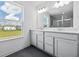 Bathroom featuring double sinks, a large mirror, and a view out the window at 3980 Canning St, Danville, IN 46122