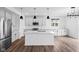 Bright kitchen featuring an island with stainless appliances, granite countertops, modern lighting, and sleek hardwood flooring at 3980 Canning St, Danville, IN 46122