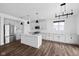 Bright kitchen featuring an island with stainless appliances, granite countertops, modern lighting, and sleek hardwood flooring at 3980 Canning St, Danville, IN 46122