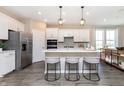 Bright kitchen featuring white cabinets, a center island with seating, stainless steel appliances, and stylish pendant lights at 16969 Cole Evans Dr, Noblesville, IN 46060
