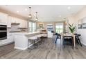 Modern kitchen with white cabinets, stainless steel appliances, pendant lighting, and an open layout to the living area at 16969 Cole Evans Dr, Noblesville, IN 46060