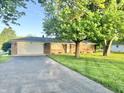 Brick home featuring attached garage and well-maintained front yard at 2892 S State Road 267, Plainfield, IN 46168