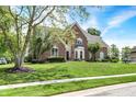 Attractive red brick home featuring a well-kept lawn and lush greenery at 8819 Anchor Bay Ct, Indianapolis, IN 46236