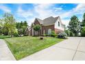 Beautifully landscaped front yard and long driveway leading to a charming brick home at 8819 Anchor Bay Ct, Indianapolis, IN 46236