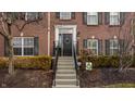 Inviting brick townhome entrance with decorative wreath and manicured landscaping at 958 Rosalind Pl, Carmel, IN 46032