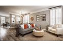 Bright living room featuring a gray sofa, accent pillows, stylish decor, and wood-look flooring at 958 Rosalind Pl, Carmel, IN 46032