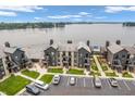 Aerial view of lakeside condos showcasing ample parking, manicured lawns, and lake views at 102 Clarendon Dr # 409, Noblesville, IN 46062