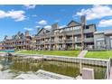 Condominium exterior featuring private balconies, lush green lawns, and docks with easy lake access at 102 Clarendon Dr # 409, Noblesville, IN 46062