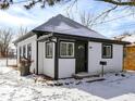 Quaint home featuring white siding, black trim, and a snow-covered yard at 5845 Rawles Ave, Indianapolis, IN 46219