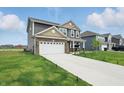 Two-story home featuring a well-manicured lawn and long driveway at 211 Walker Dr, Whiteland, IN 46184