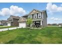 Two-story home featuring a well-manicured lawn and attached two-car garage at 211 Walker Dr, Whiteland, IN 46184