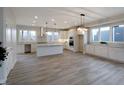 Open kitchen with island, stainless steel appliances, and white cabinetry at 5286 Stonehaven Ln, Columbus, IN 47201
