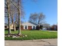 Traditional brick home with green lawn, white shutters, and attached garage at 3230 Meadowcrest Dr, Anderson, IN 46011
