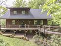 Rustic log home with spacious deck, wooden railings, and beautiful landscaping with flowering shrubs at 6486 Coyote Dr, Nineveh, IN 46164