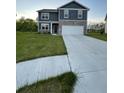 Two story home with blue siding, stone veneer, large front yard, and two car garage at 7108 Parkstay Ct, Indianapolis, IN 46113