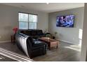 Living room with wood laminate floors, two leather couches and large window at 7108 Parkstay Ct, Indianapolis, IN 46113