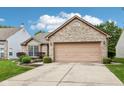Charming brick home features a two-car garage, manicured lawn, and a welcoming entrance at 778 Kingston Cir, Brownsburg, IN 46112