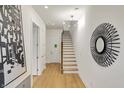 Bright foyer with modern light fixture, white walls, and open staircase with light wood treads at 527 E North St, Indianapolis, IN 46204