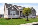 Gray farmhouse exterior with white trim, stone accents, and a landscaped lawn at 11362 Selsey Rd, Fishers, IN 46040