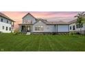 Spacious backyard featuring a well-maintained lawn, covered patio, and white siding on a two-story home at 15776 Allure Dr, Westfield, IN 46074