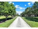Long paved driveway through a tree-lined yard leading to a charming home at 13208 State Road 32 E, Noblesville, IN 46060
