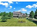 A beautiful brick home with a well-manicured lawn and vibrant flower beds at 13208 State Road 32 E, Noblesville, IN 46060