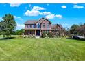 A beautiful brick home with a well-manicured lawn and vibrant flower beds at 13208 State Road 32 E, Noblesville, IN 46060