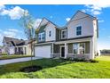 Two-story house with green and white siding, a tree in the front yard, and a grassy lawn at 573 Carroll St, New Whiteland, IN 46184