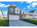 Two-story house with green and white siding, a driveway, and a view of neighboring homes at 573 Carroll St, New Whiteland, IN 46184