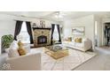 Elegant living room with a cozy fireplace, modern white sofas, and a stylish glass coffee table, ideal for gatherings at 1560 Cold Spring Dr, Brownsburg, IN 46112