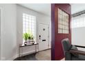 Bright entryway with white walls, glass block window, dark wood floors, and a stylish accent table at 610 N Park Ave, Indianapolis, IN 46204
