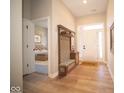 Inviting foyer with a custom built-in bench and storage, leading to a bedroom and the front door at 7936 Beaumont Green Pl, Indianapolis, IN 46250