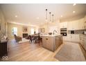 Open floor plan showcasing a spacious living room, dining area, and modern kitchen with an island at 7936 Beaumont Green Pl, Indianapolis, IN 46250