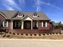 Charming brick home with dormer windows, well-manicured landscaping, and inviting entrance at 7942 Beaumont Green Pl, Indianapolis, IN 46250