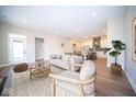 Bright living room with modern decor, hardwood floors, and an open layout leading into the dining and kitchen areas at 7942 Beaumont Green Pl, Indianapolis, IN 46250