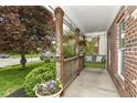 Inviting covered front porch features wooden posts, hanging flower baskets, swing, and lush landscaping at 11193 Harriston Dr, Fishers, IN 46037