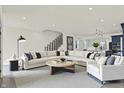 Bright and spacious living room featuring a large sectional sofa and open staircase at 1218 Orange St, Indianapolis, IN 46203