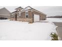 Brick home with attached garage, snow-covered yard at 1157 Paul Revere Dr, Mooresville, IN 46158