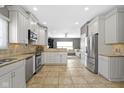 Open kitchen featuring white cabinetry, stainless steel appliances, and granite countertops, seamlessly flowing into the living area at 9955 Woodstock Way, Fishers, IN 46037
